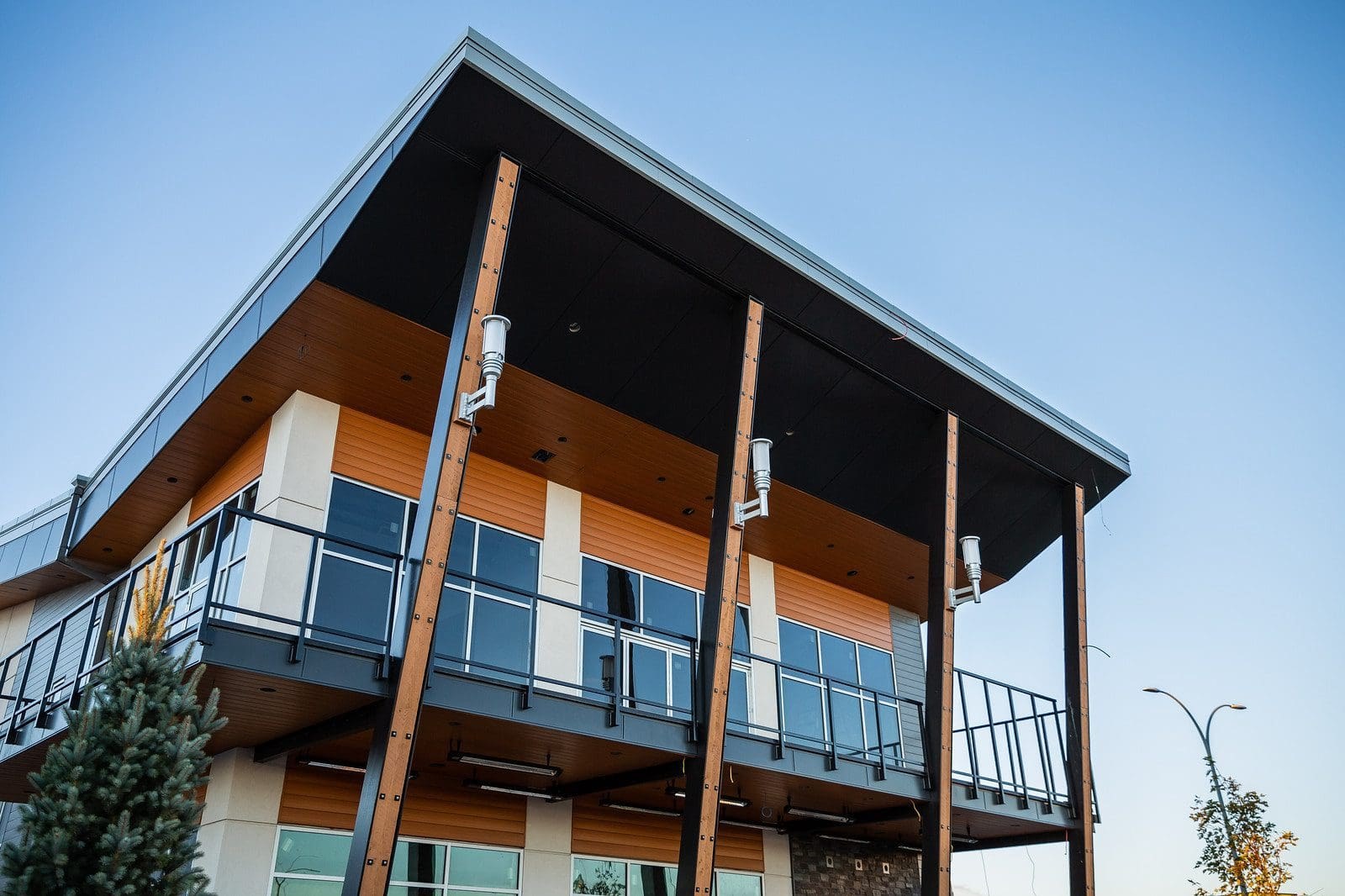 Modern home with FastPlank woodgrain aluminum accents at dusk — photo courtesy of FastPlank / Engage Building Products