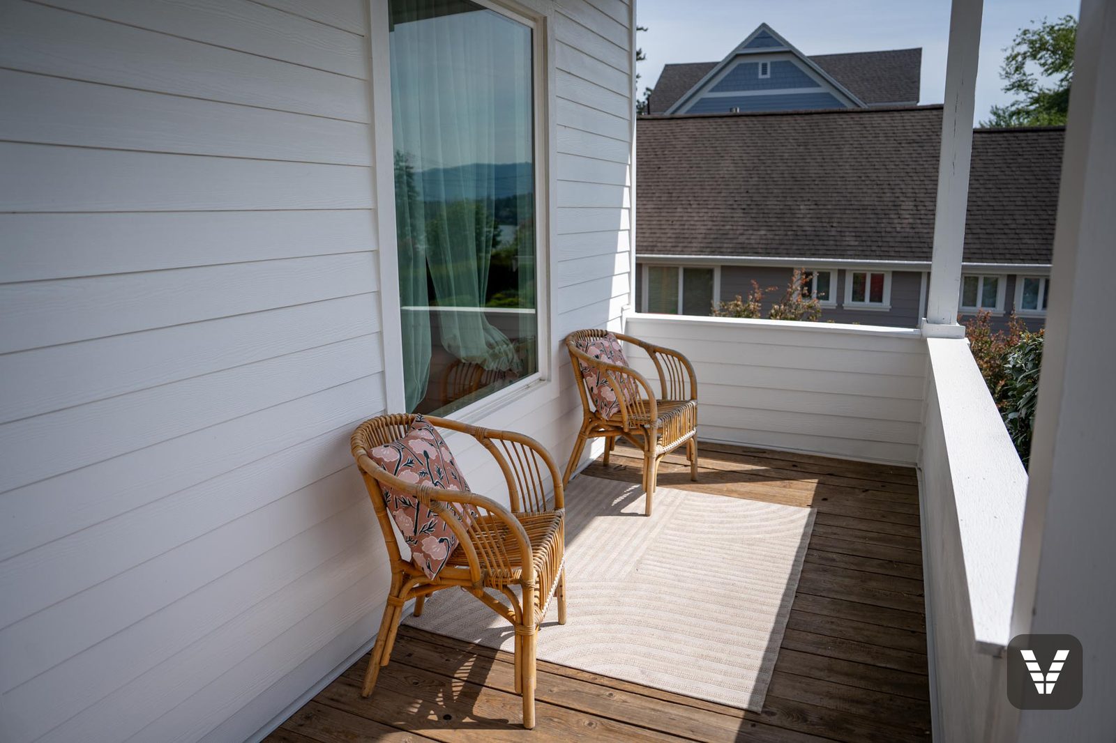 The porch after the re-side — new white lap behind the original decking, chairs back in place