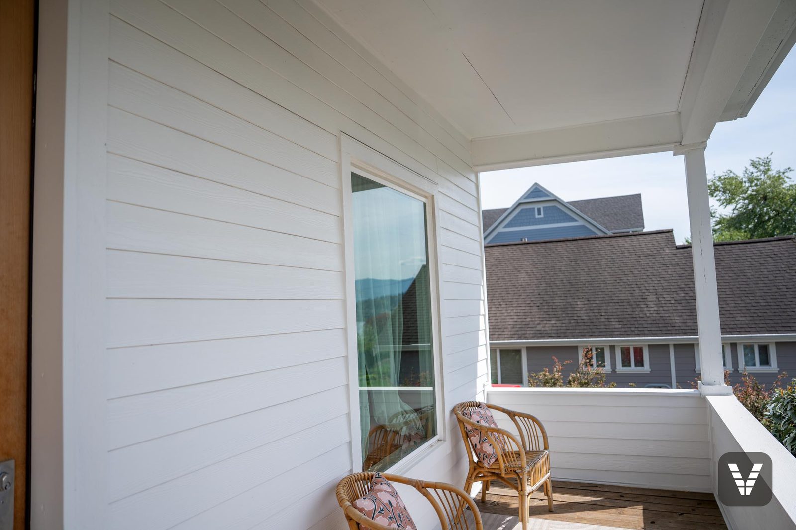 On the porch — fresh white lap and trim at the corner post — Siding & Window Vault project in Bellingham, WA
