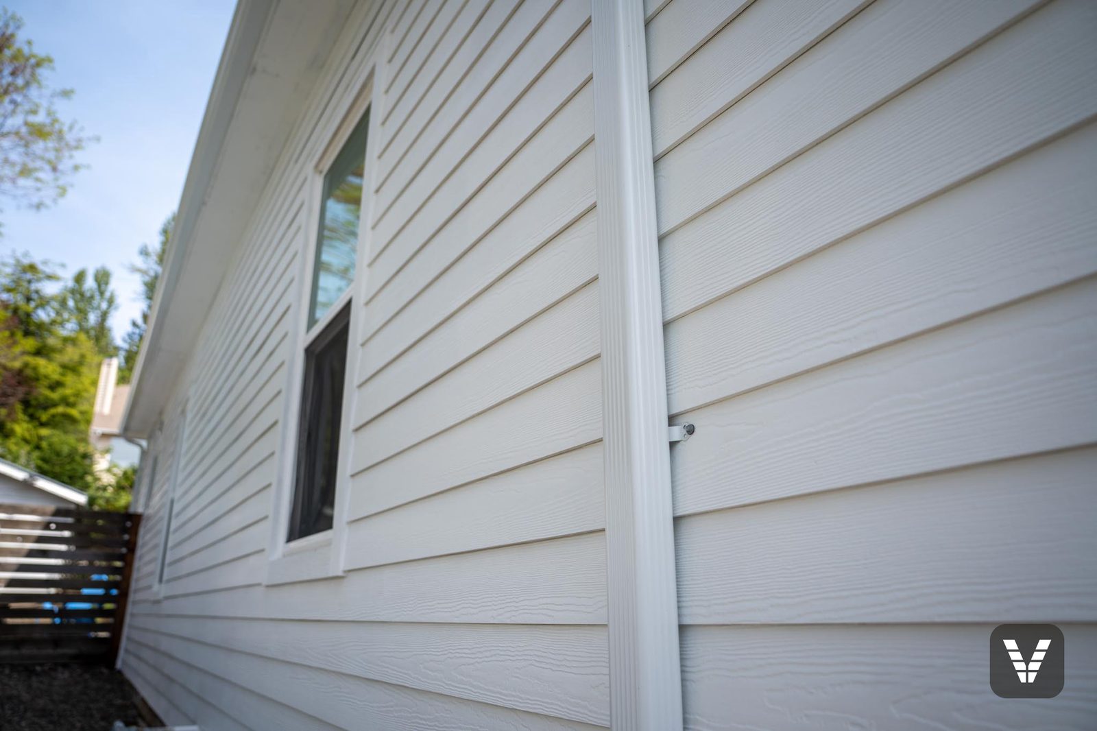 Corner detail with the new downspout over crisp 5-inch lap lines