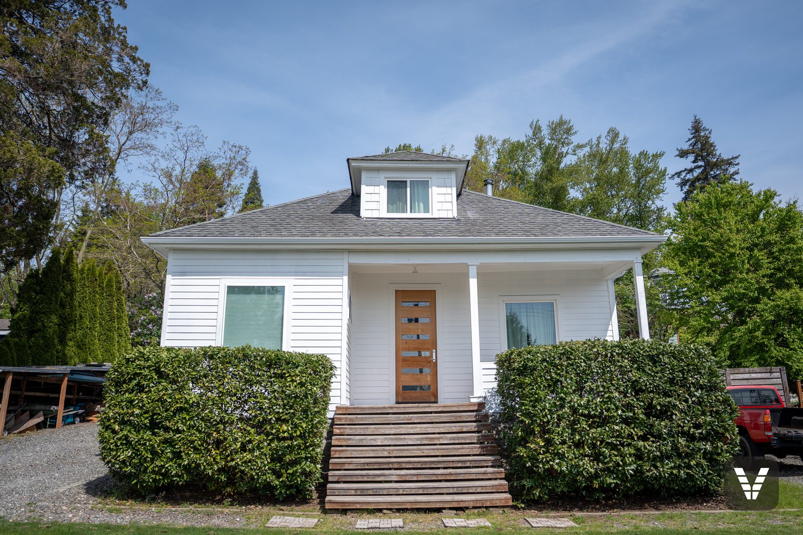 The 1914 bungalow after its re-side — white HardiePlank at a 5-inch reveal, shingled cupola dormer, original porch — after, SWV project in Bellingham, WA
