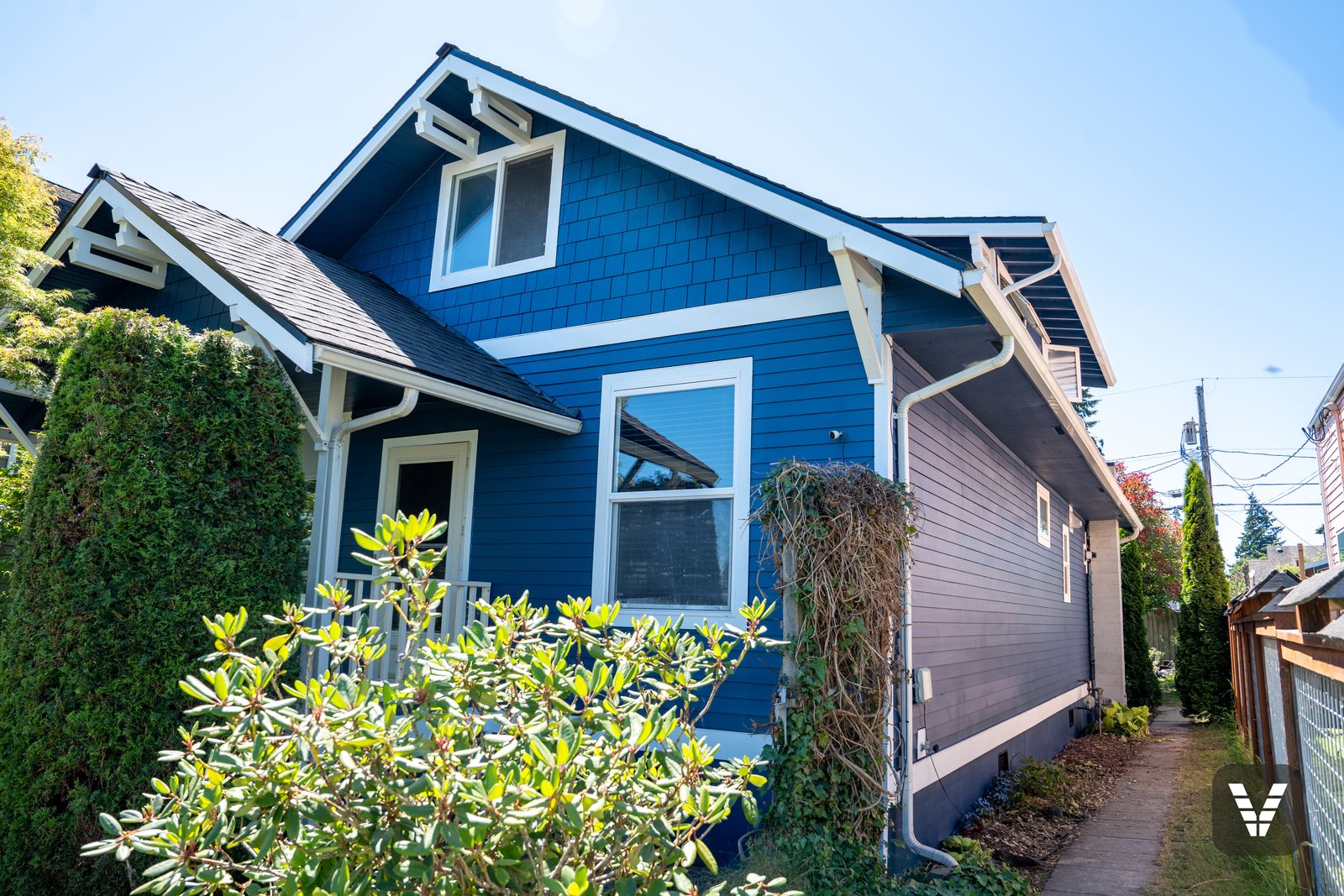 Front-left corner — shingle gable, brackets, and new lap below