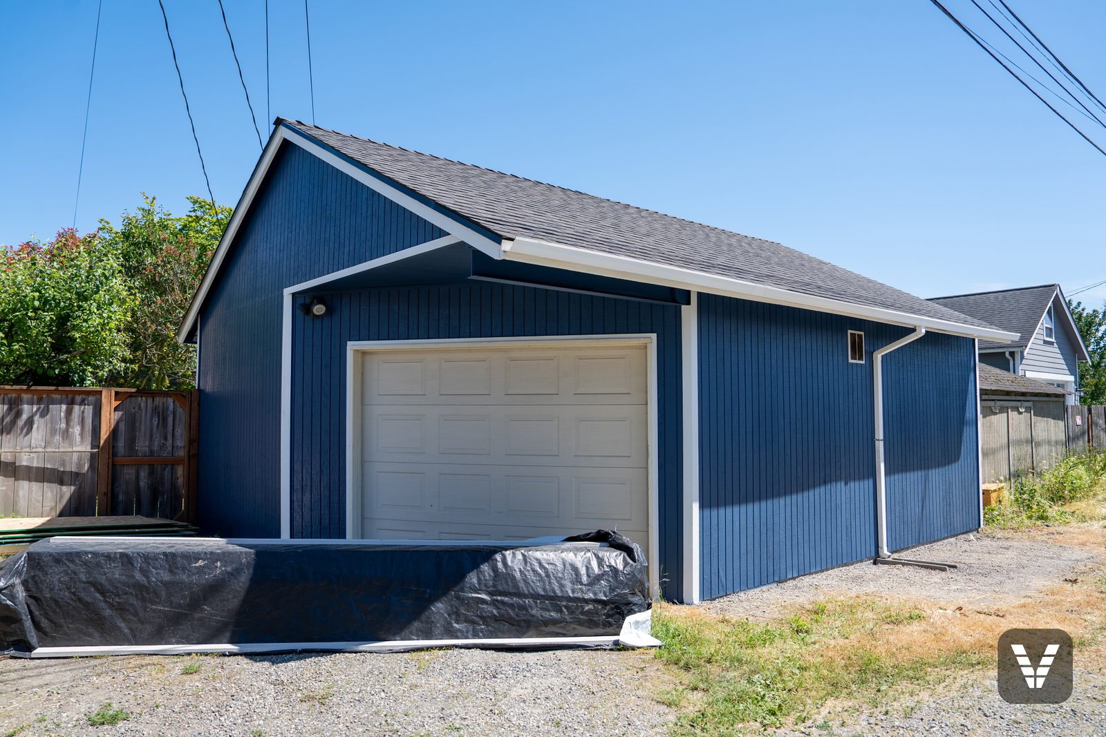 The detached garage, repainted to match the house — two unpaintable corners replaced before the color went on
