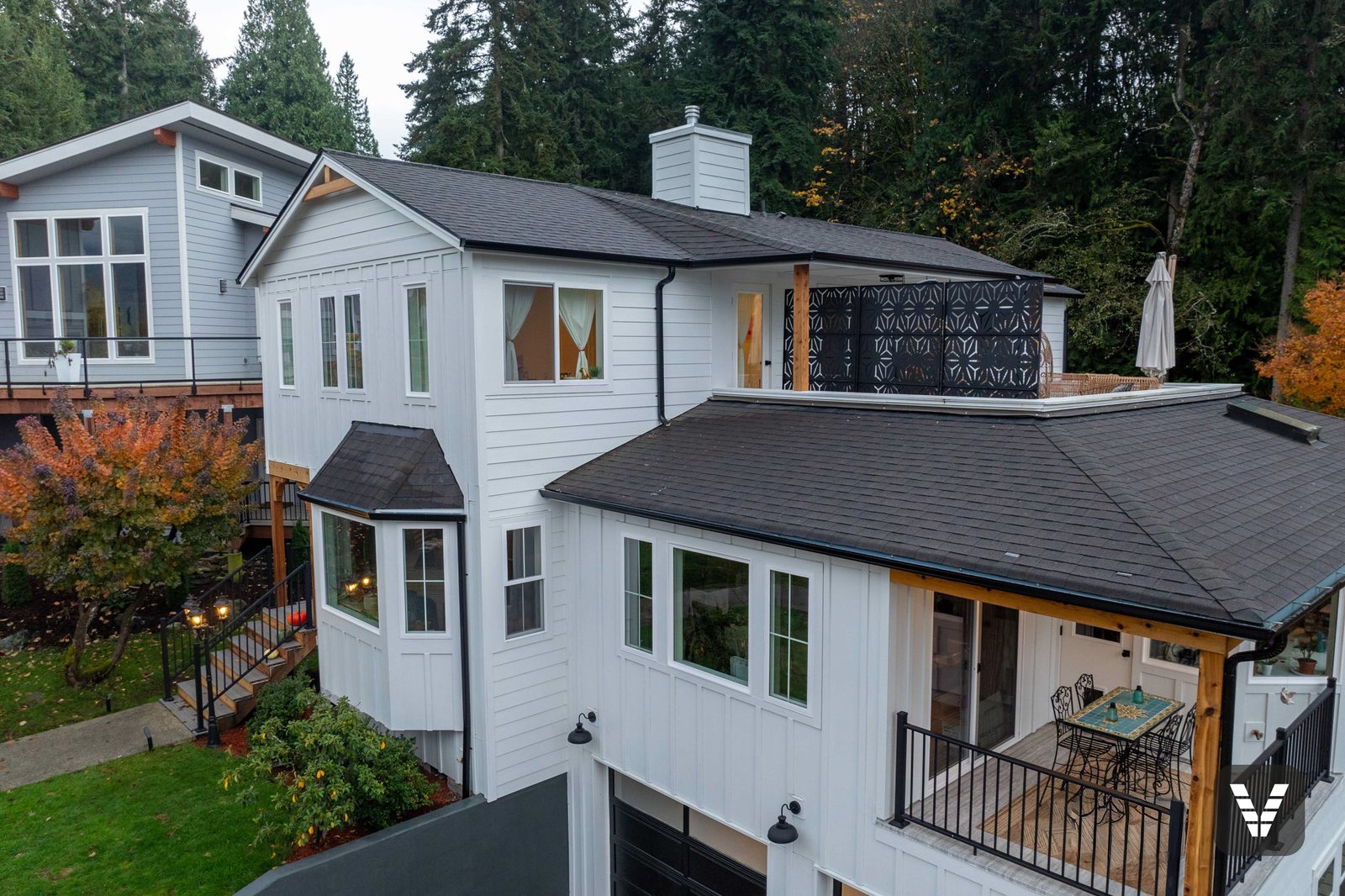 Drone view of the Arctic White board-and-batten front with the rooftop deck beyond