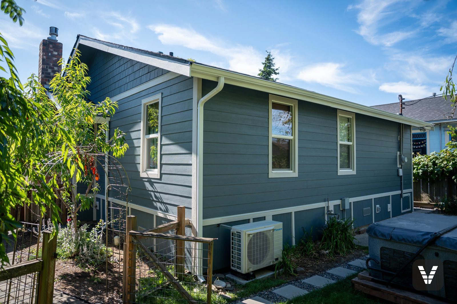 Rear elevation in the garden — Evening Blue HardiePlank, shingle gable, and panel skirting with Cobble Stone trim in Bellingham, WA — Siding & Window Vault project in Bellingham, WA