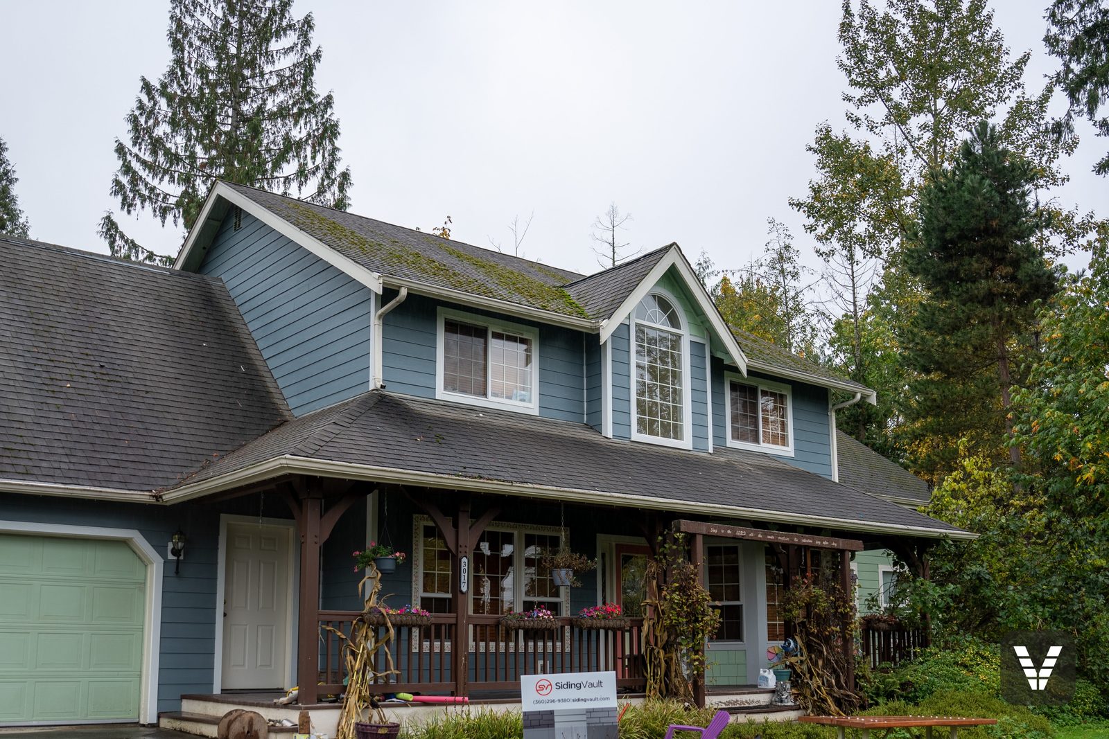 Front-left view — Boothbay Blue lap, the timber porch, and the project sign