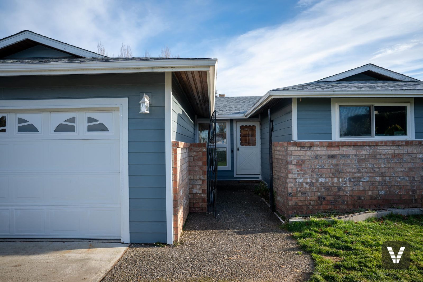 The entry courtyard — Boothbay Blue lap, the white storm door, and the iron gates that stayed