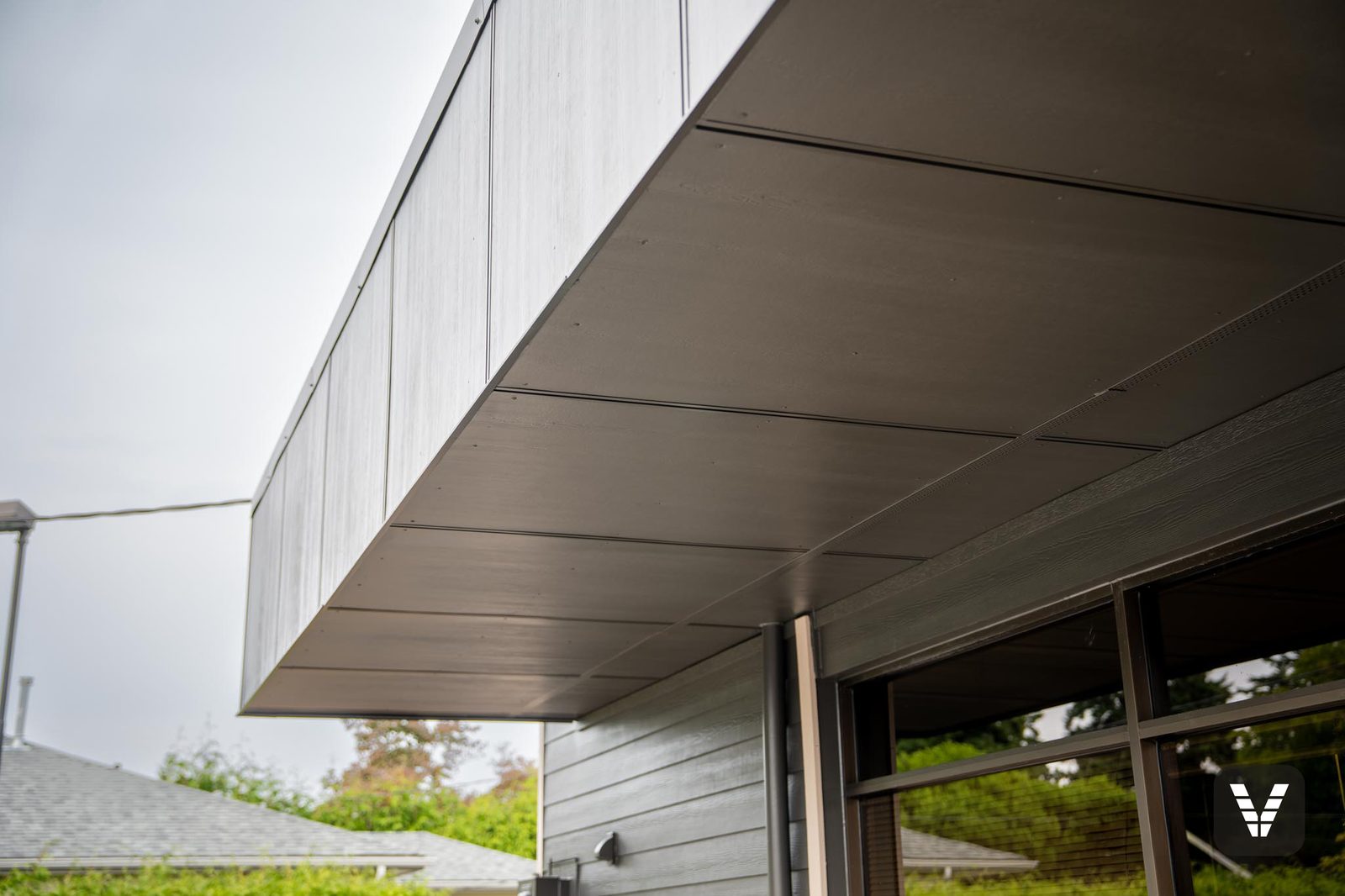 The redesigned entry overhang — sheeted and clad in HardiePanel with commercial seam flashing for a solid, industrial profile