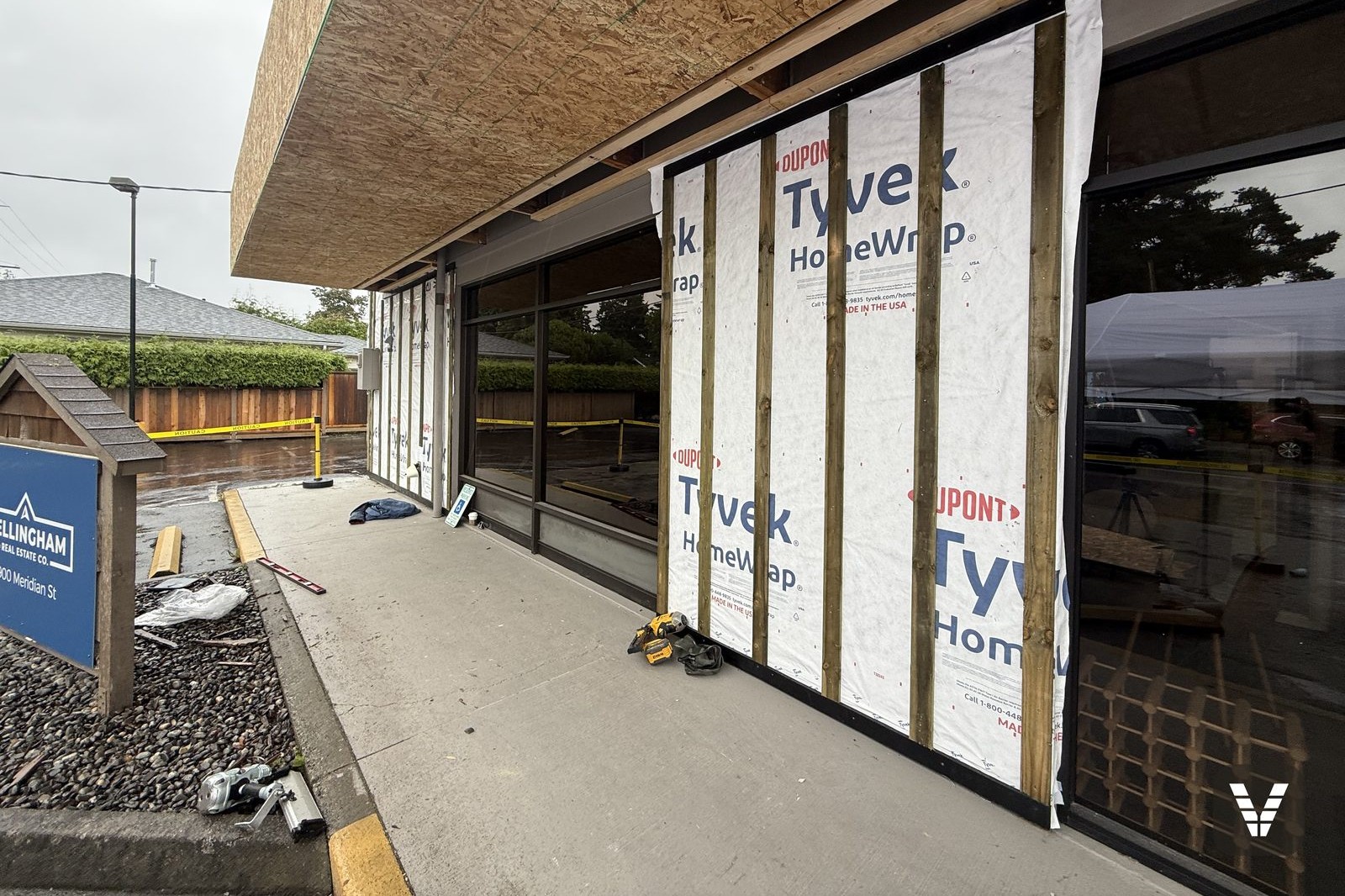 Tear-off in progress on a Bellingham commercial re-side — original T1-11 exposed and evaluated