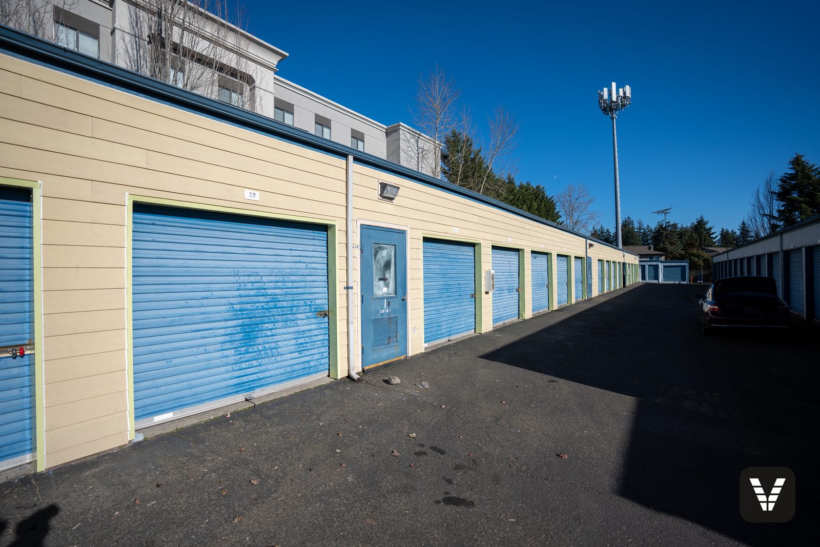 The front storage row in fresh primed HardiePlank above the blue roll-up doors