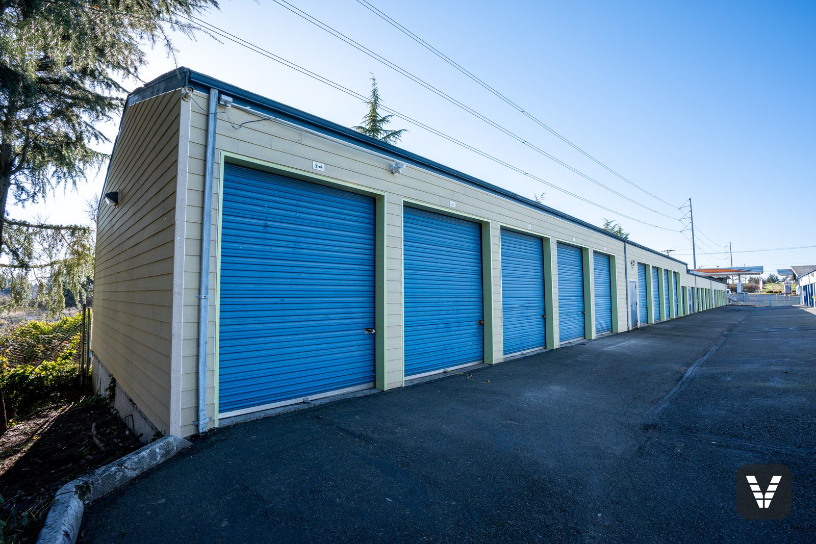 A storage building from the drive aisle — new lap on every wall above the custom-wrapped door trim