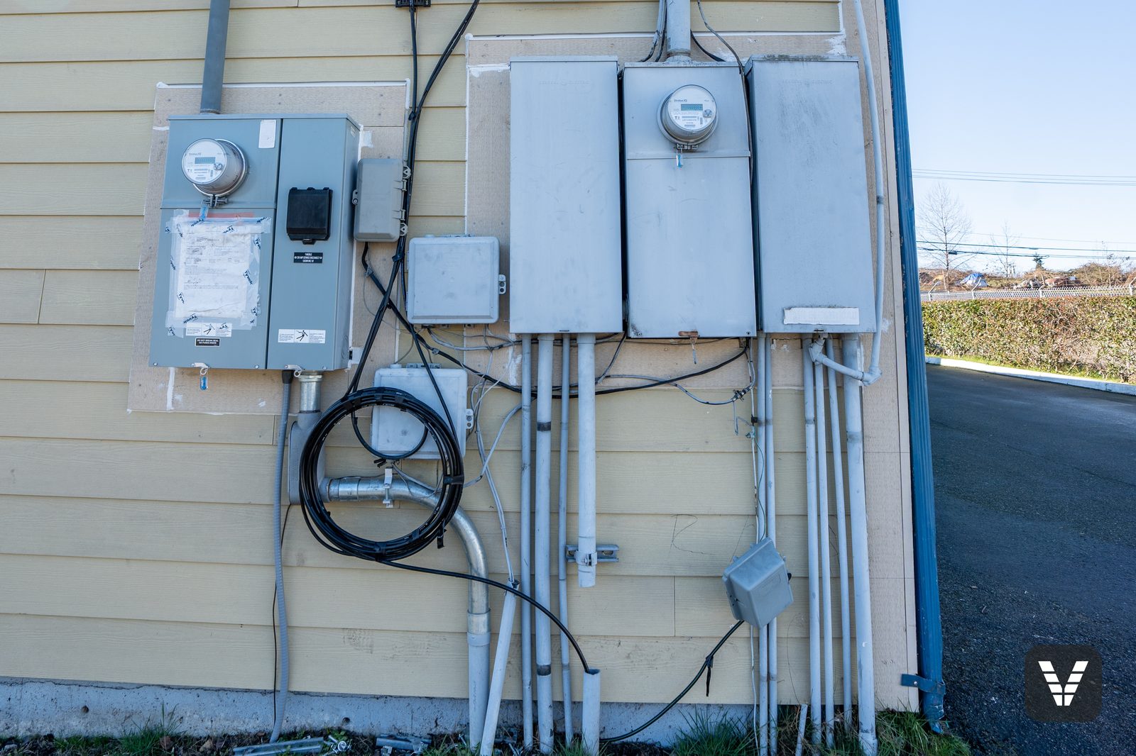 The meter bank — every meter, panel, and conduit removed and remounted on the new siding