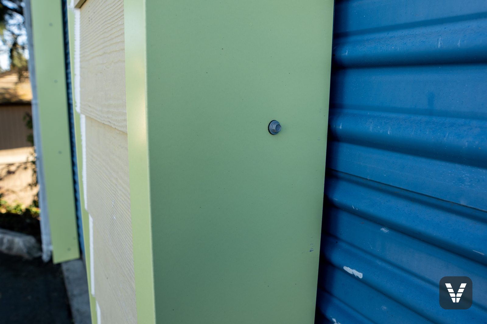 Up close — the custom primed-metal trim wrap encasing the inner door trim, z-flashing built into its top piece, beside fresh Cedarmill lap