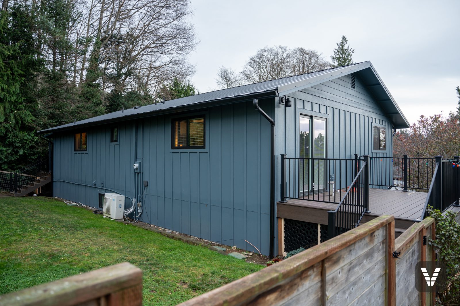 Corner view with new sliding door, black Andersen windows, and Trex deck — Siding & Window Vault project in Anacortes, WA
