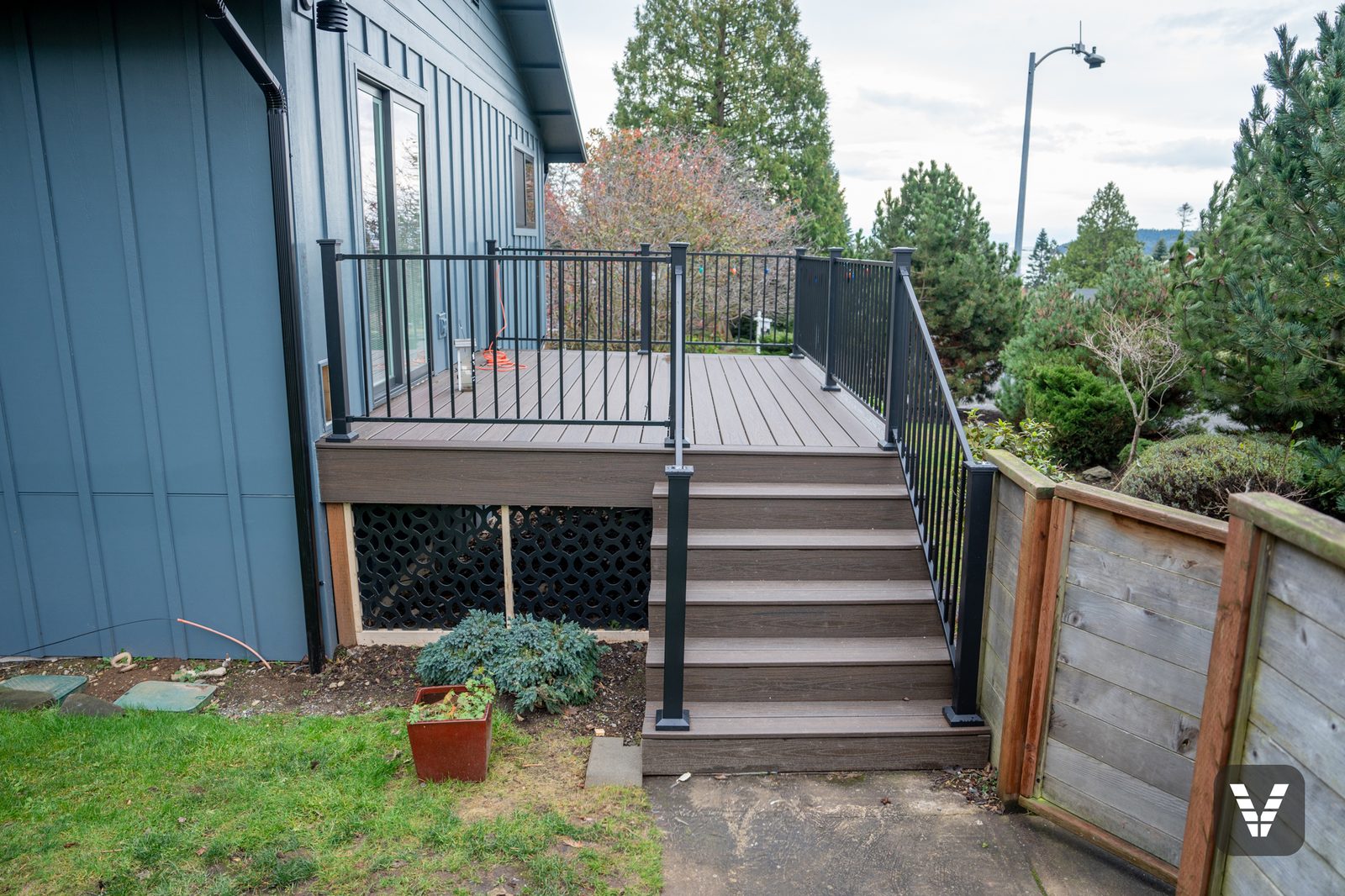 Trex Transcend stairs with RDI MetalWorks steel railing and black lattice skirting — Siding & Window Vault project in Anacortes, WA