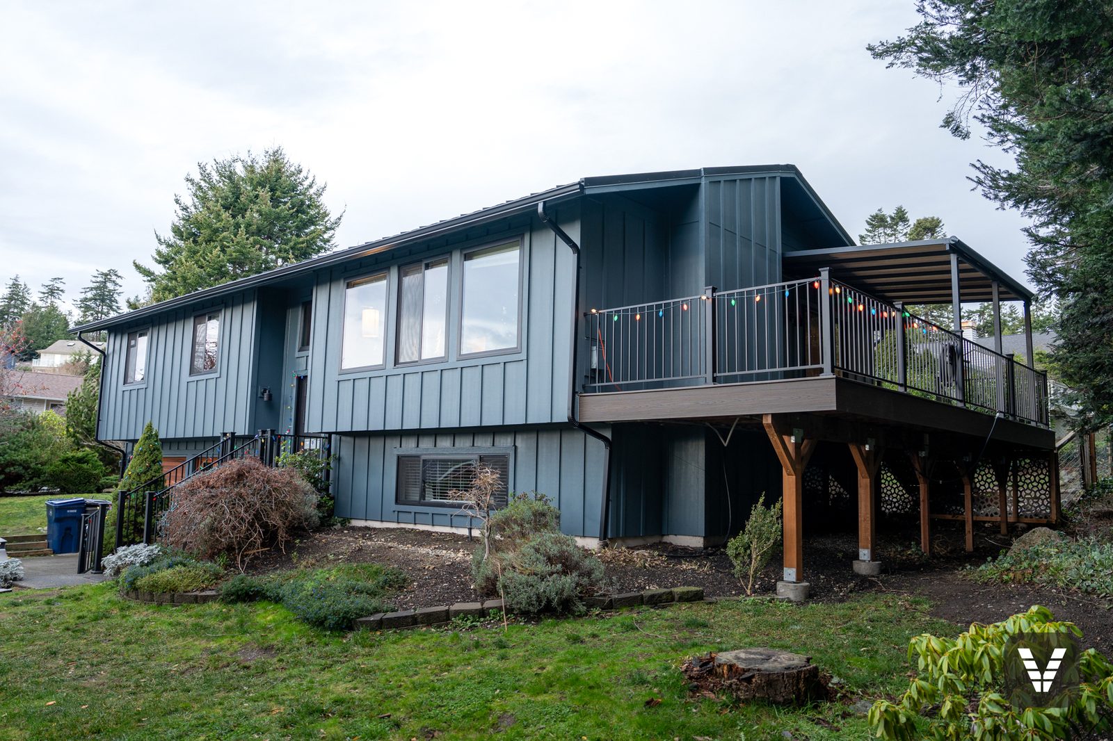 Front elevation with new Evening Blue Hardie siding and covered Trex deck — Siding & Window Vault project in Anacortes, WA