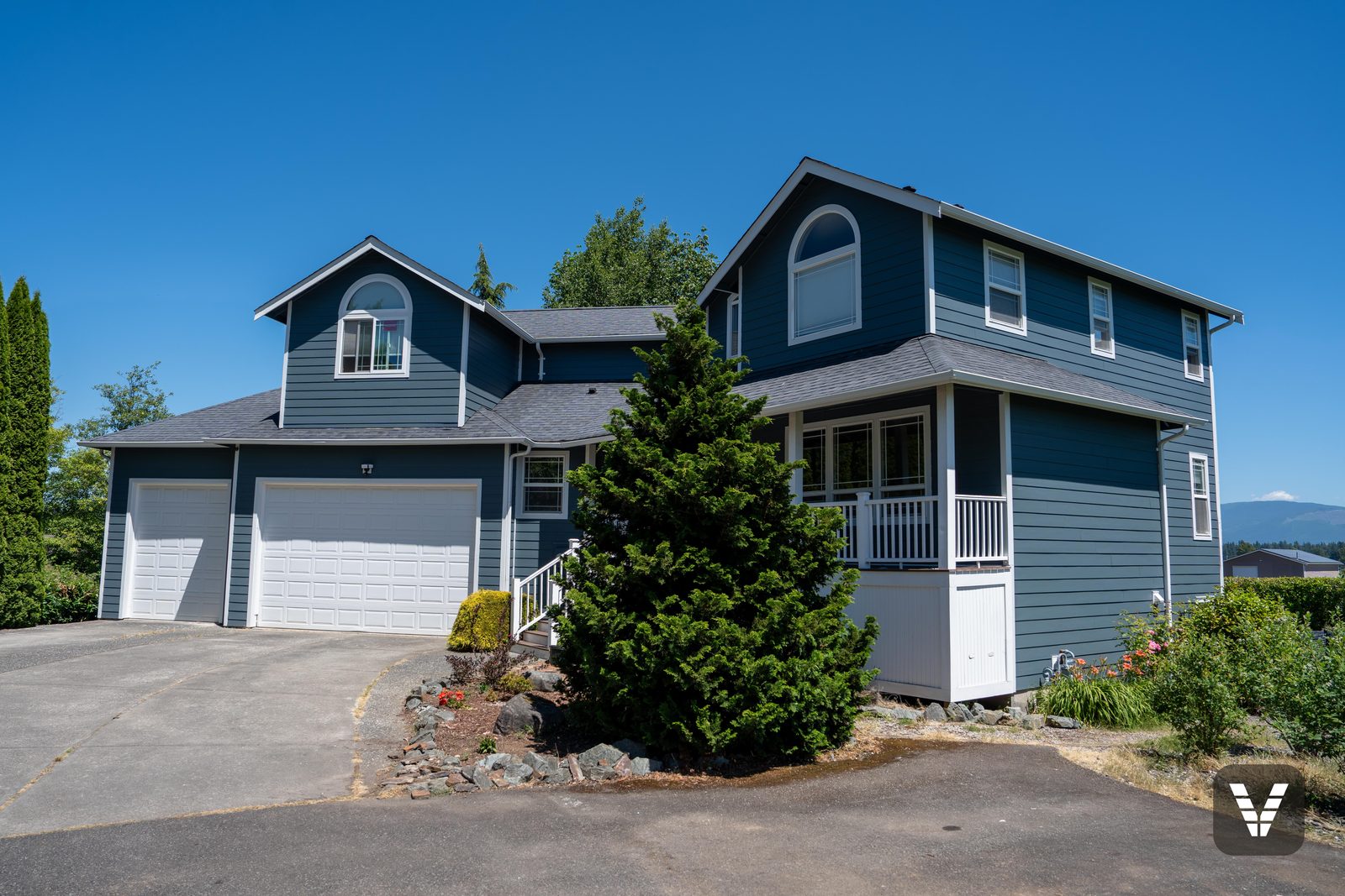 The finished two-story in Evening Blue James Hardie lap with Arctic White trim and arched gable windows, Bellingham WA — Siding & Window Vault project in Bellingham, WA