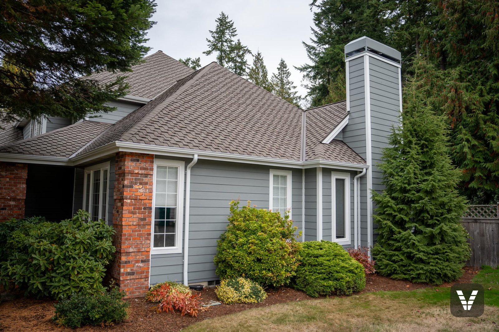 The re-clad chimney rising over the entry corner in Gray Slate lap