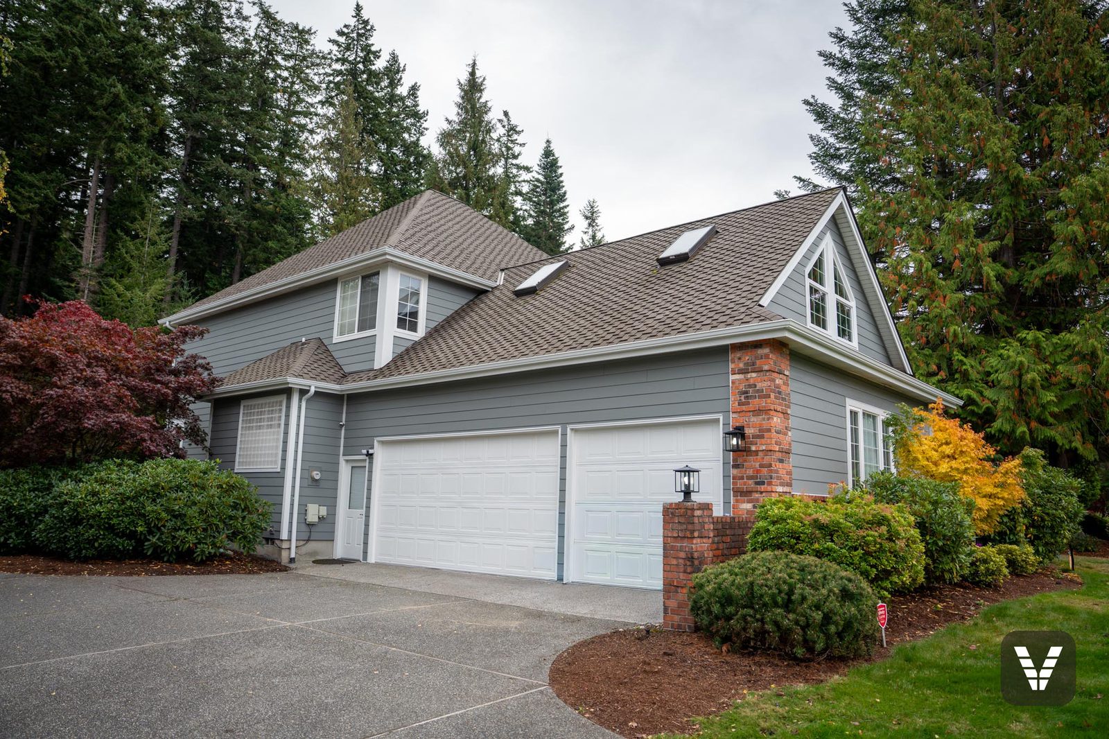 Garage side — both doors freshly painted, new lap and trim above — Siding & Window Vault project in Anacortes, WA