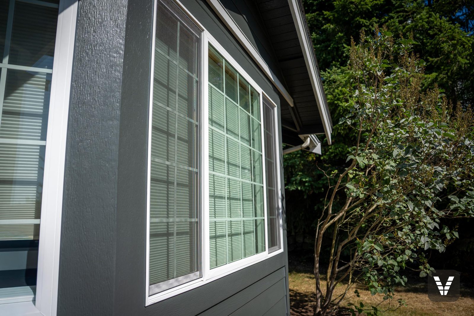 One of twelve new Milgard V300 Trinsic windows — colonial grids on the street-facing walls, flashed and trimmed in Hardie