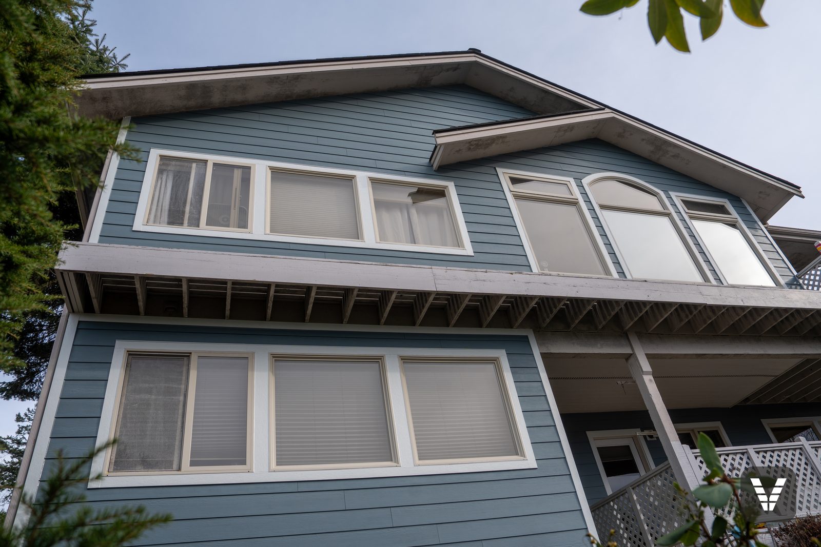 The rear elevation from below — new walls, arched window, original eaves awaiting the owners' painter