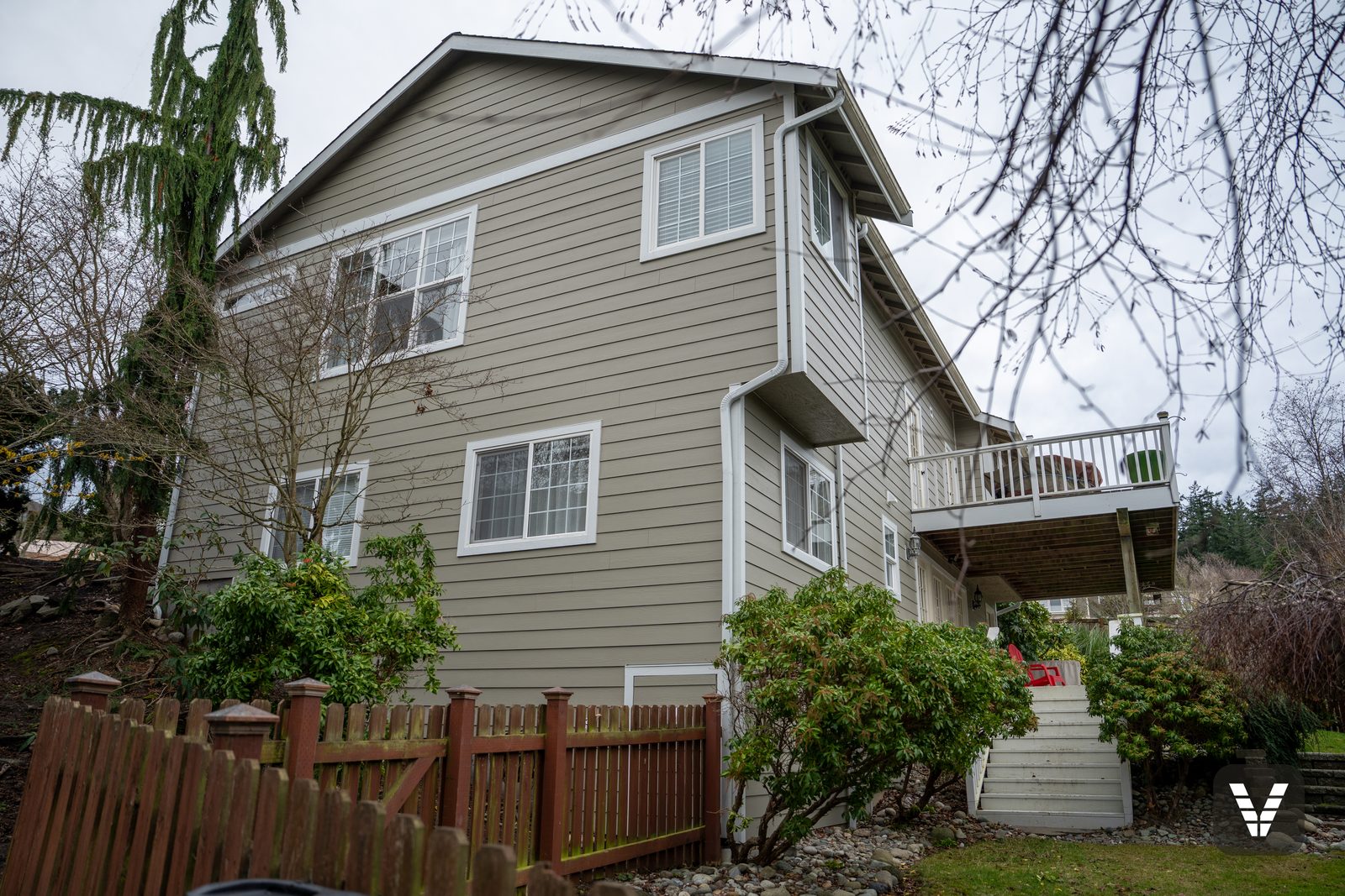 Side elevation with the upper deck and new HardieTrim fascia — Siding & Window Vault project in Anacortes, WA