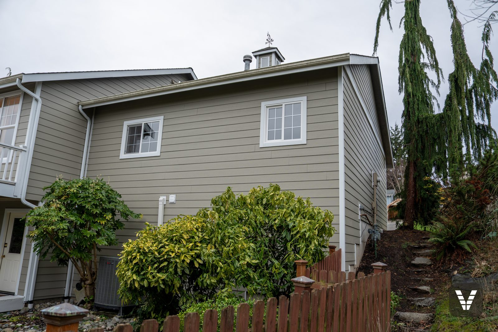 Rear corner with the cupola above fresh Monterey Taupe siding