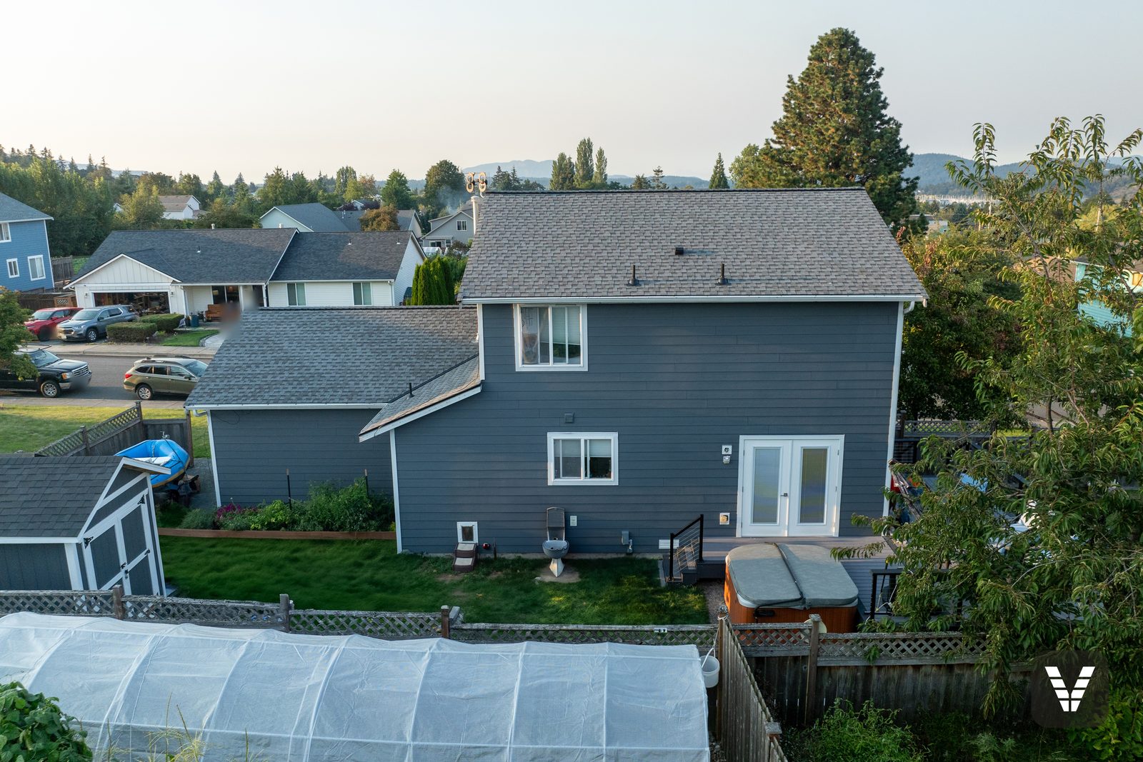 The rear of the home from the air — fresh lap on every wall, French doors trimmed in white