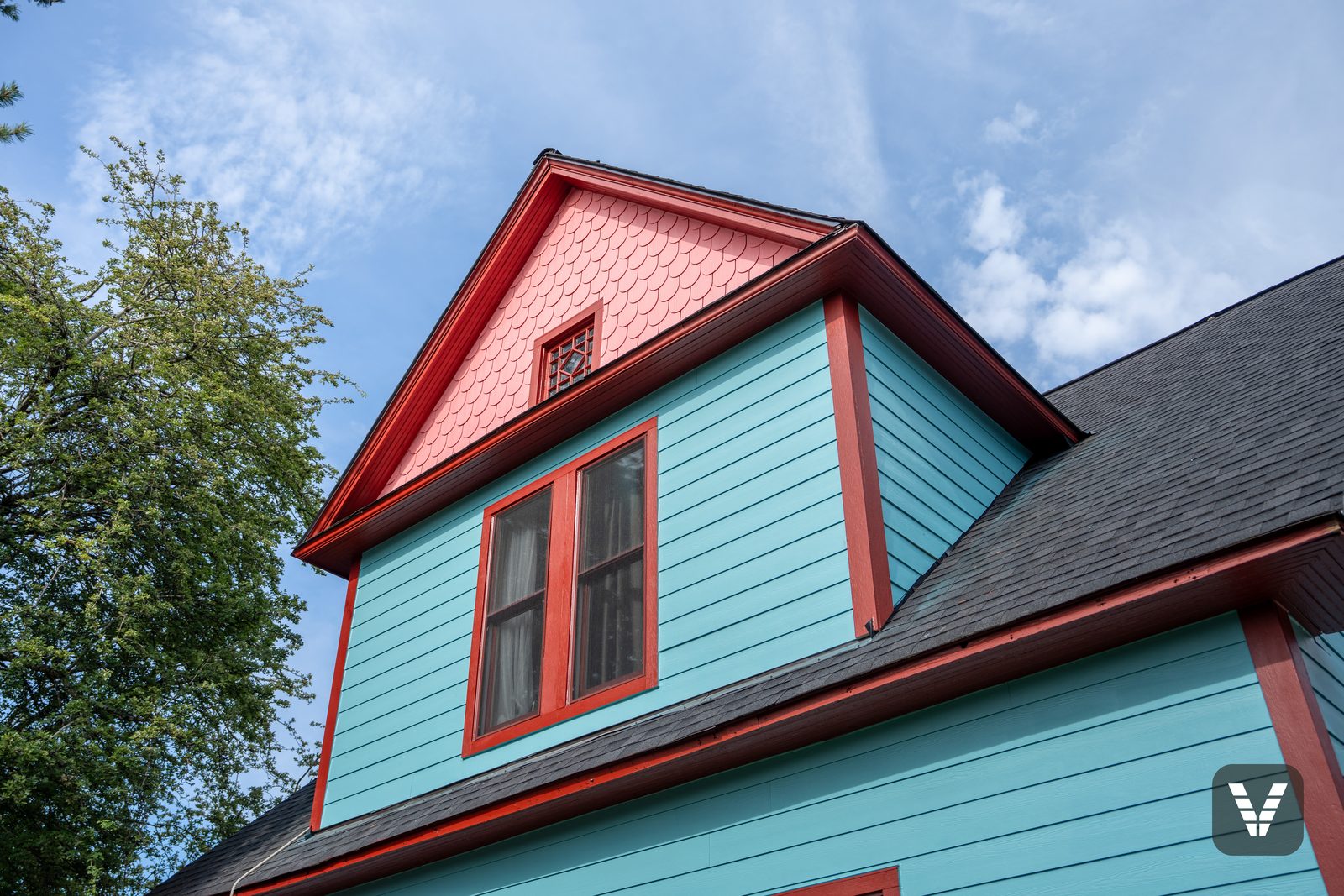 The dormer — coral Allura scalloped shingles, crimson casings, and the original leaded attic window back in place