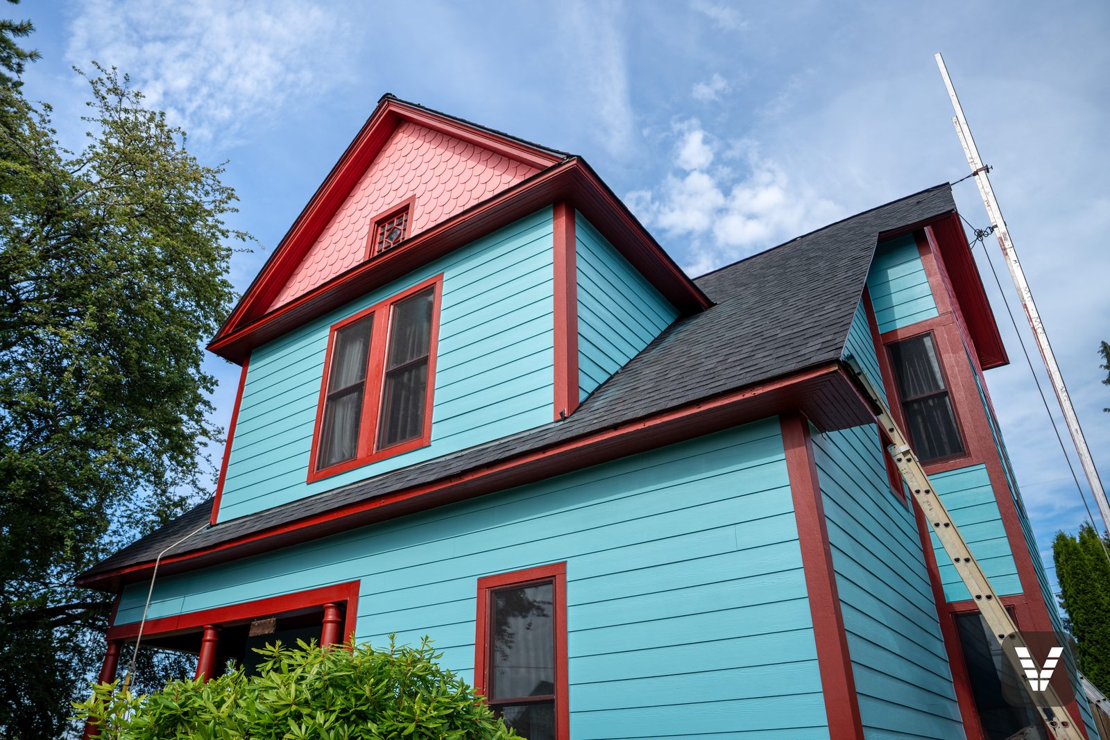 Looking up at the gable — fishscale scallops over turquoise lap in the final days of painting — Siding & Window Vault project in Bellingham, WA