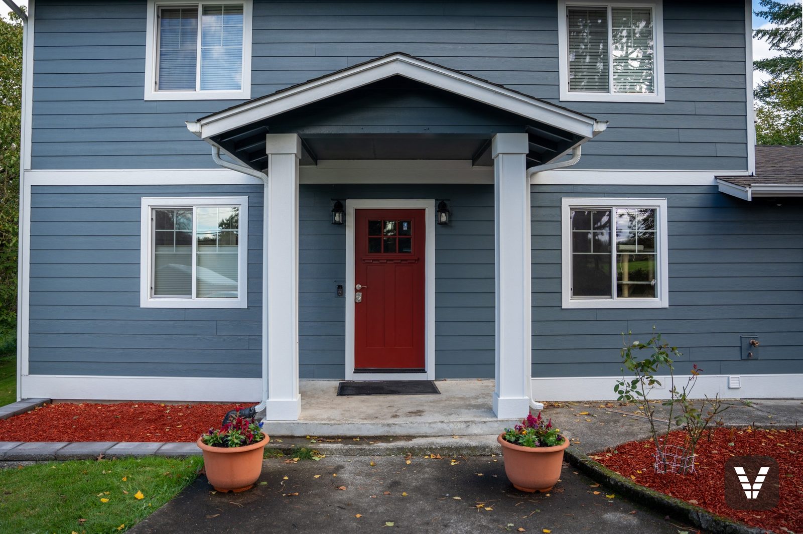 The entry bay straight on — red Codel craftsman door under the rebuilt porch — Siding & Window Vault project in Ferndale, WA
