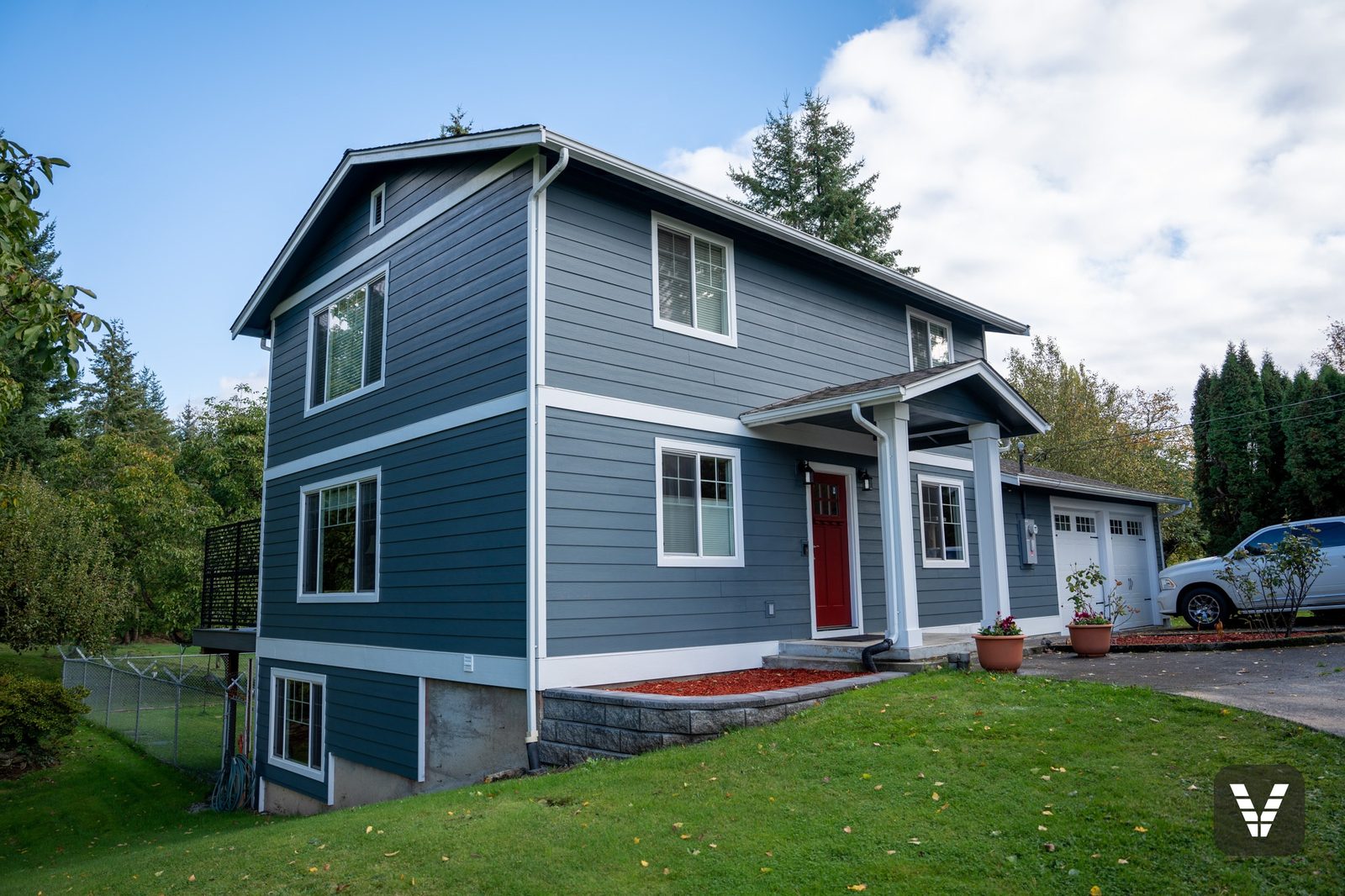 Finished two-story in Evening Blue James Hardie lap siding with Arctic White trim and a red craftsman entry door, Ferndale WA