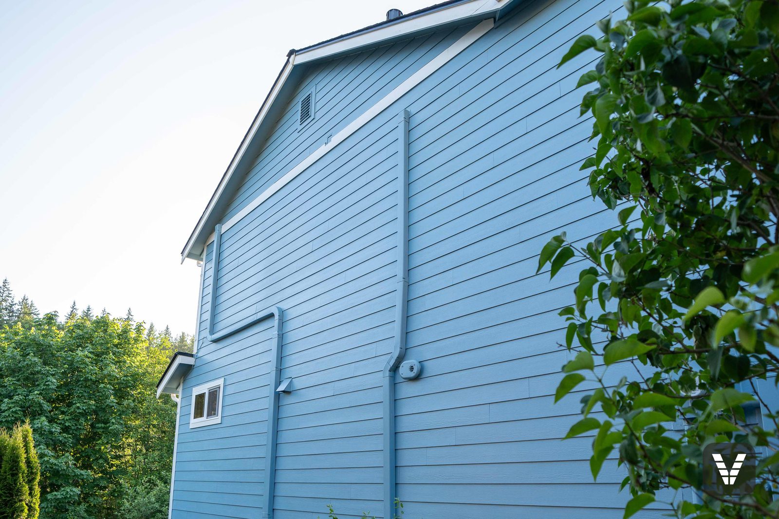 The side elevation — new lap running clean past the heat pump and garden beds