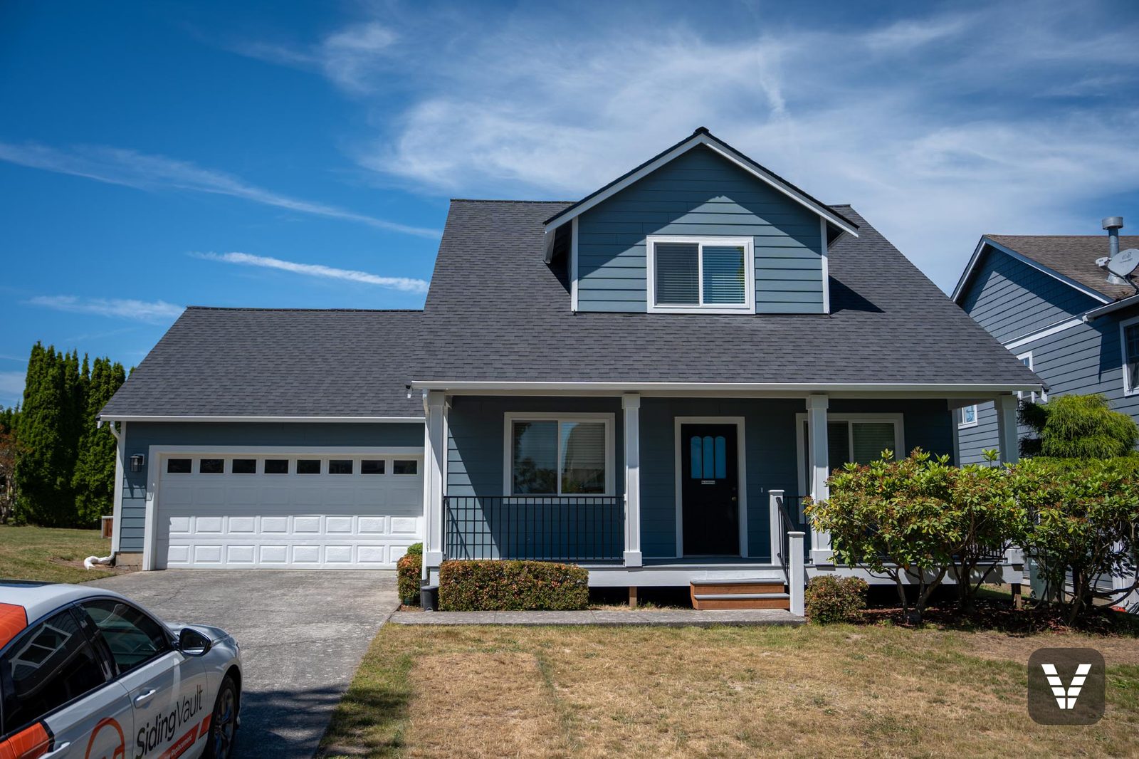 The finished front straight on — Boothbay Blue lap, new windows, and the rebuilt porch