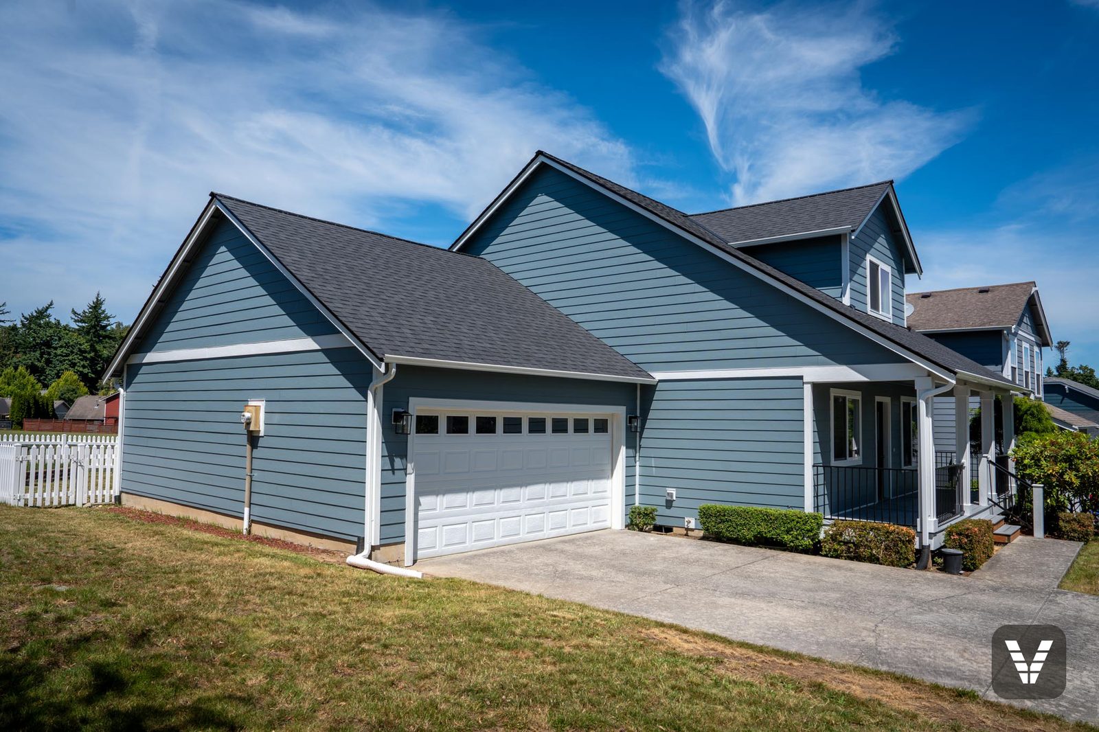The garage wing in Boothbay Blue lap with Arctic White trim and new lantern sconces