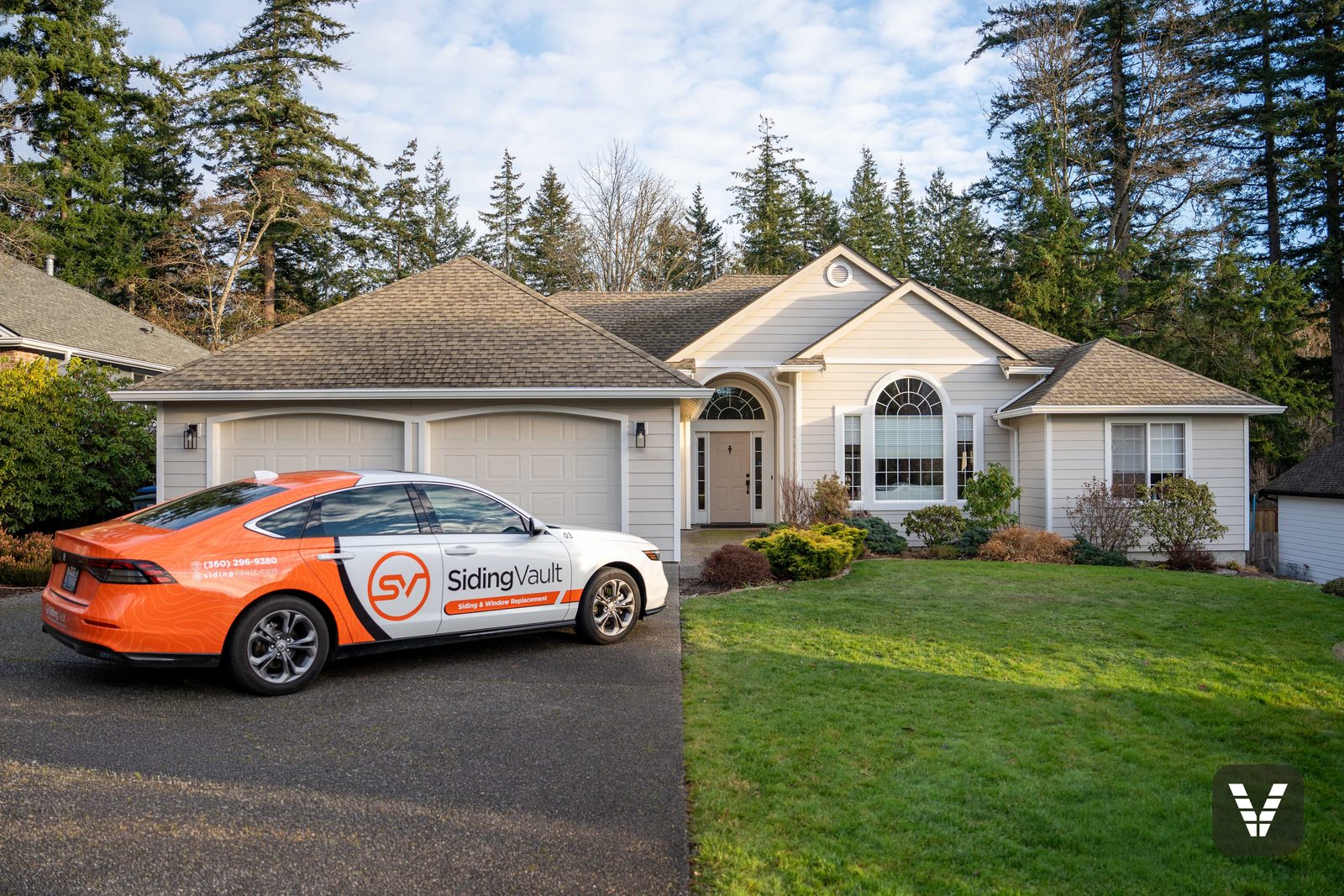 The branded Siding Vault car in a Bellingham driveway below a finished re-side — the same local crew on every job