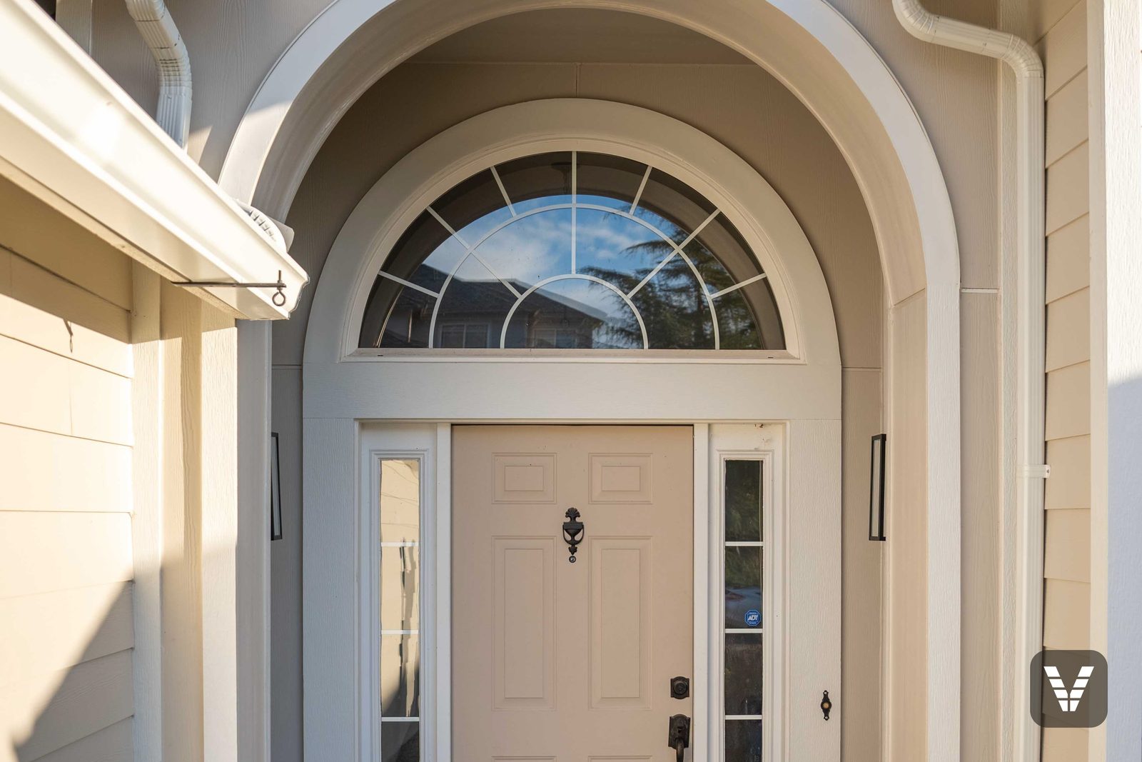 The entry alcove — arched transom framed in Arctic White trim, curves formed without seams — Siding & Window Vault project in Bellingham, WA