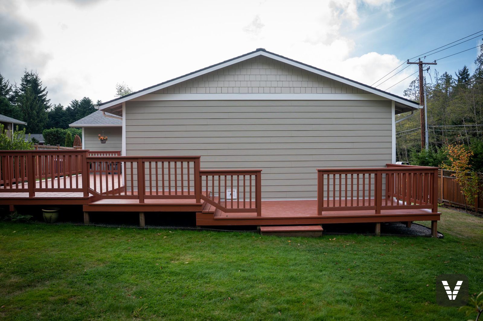 The rear of the home over the big red-railed deck, gable in Cobblestone shingle