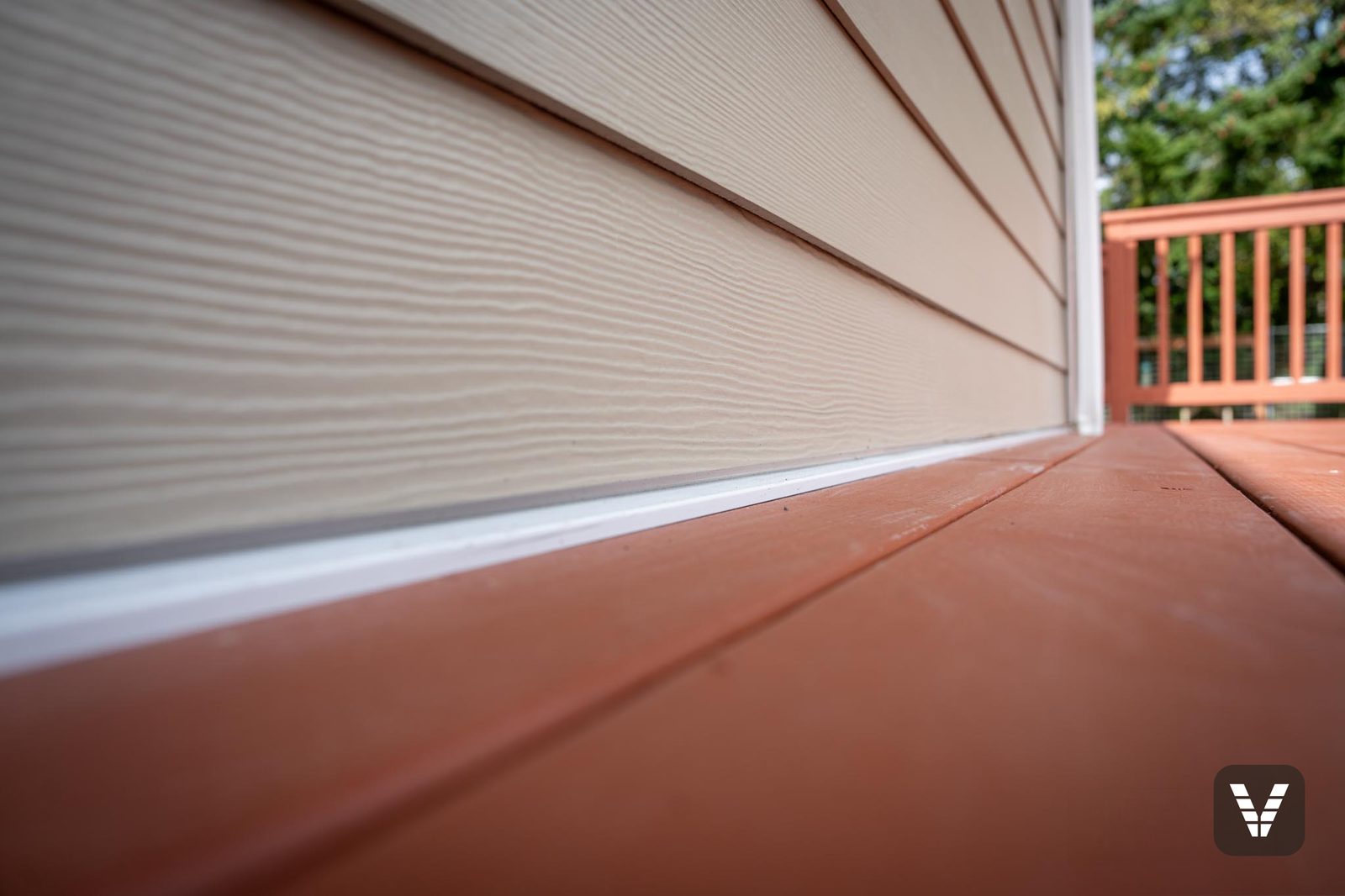 Where the colors meet — taupe lap, white band, red deck boards