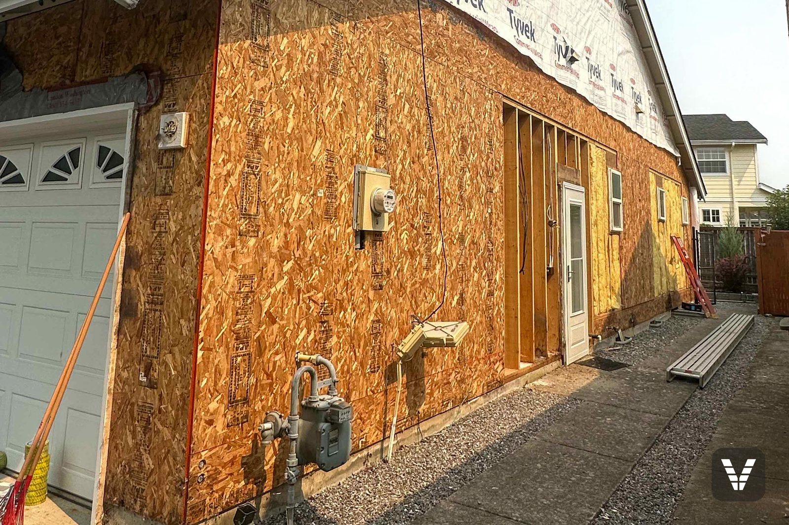 Stripped to the studs' sheathing — bare OSB inspected wall by wall before the Tyvek wrap closed it back up