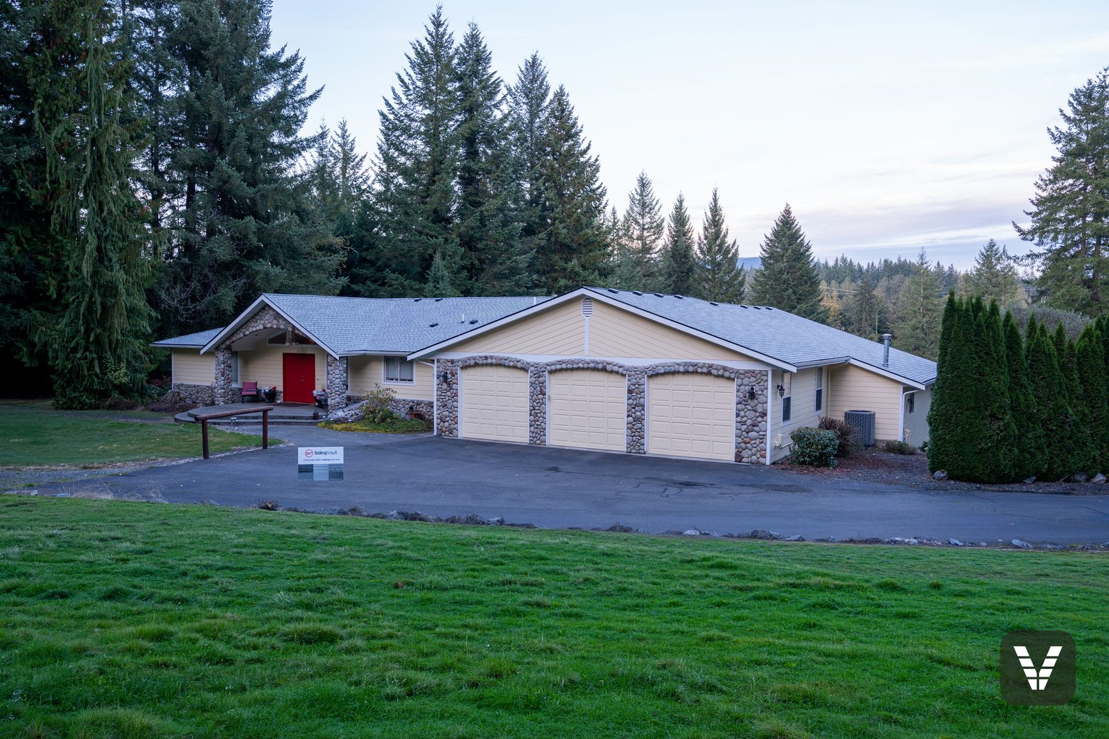 The full front — three-car garage, rock arches, and the re-sided, repainted main house — Siding & Window Vault project in Lake Stevens, WA