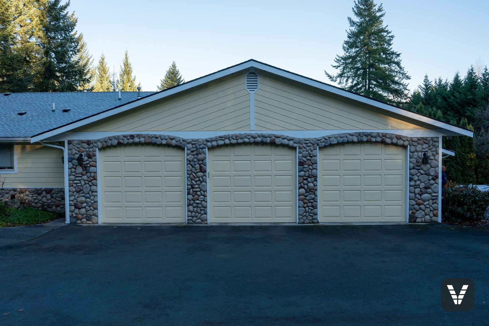 Three-car garage with river-rock arches, doors puttied and painted — Siding & Window Vault project in Lake Stevens, WA