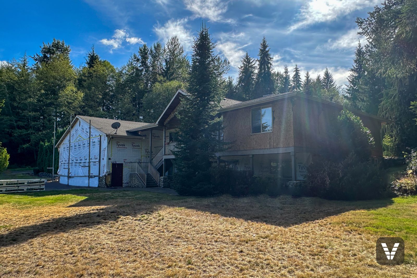 Mid-project — hangar in housewrap, walls in fresh sheathing (before side of pair) — Siding & Window Vault project in Lake Stevens, WA
